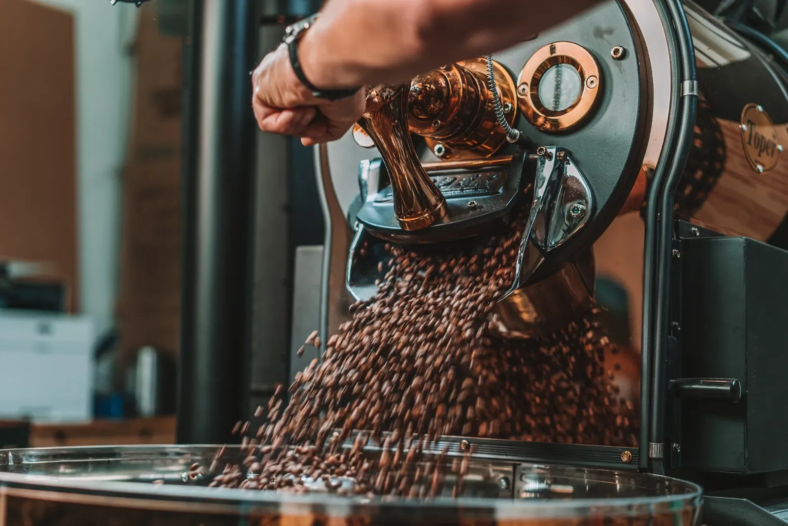 most fabulous picture of someone emptying roasted beans from green and copper Toper roaster
